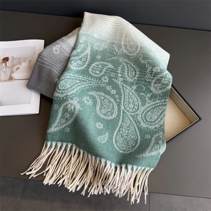 Detail of paisley pattern on sage green gradient cashmere feel scarf with soft tassels