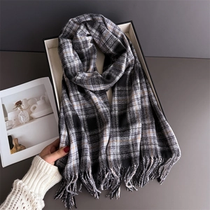 Detail of British plaid scarf with soft tassels in elegant gift box packaging