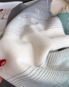 Detail of soft fringe cashmere-like scarf with color-block stripes and jacquard texture