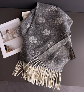 Detail of grey knitted scarf with white camellia jacquard and fringe tassels