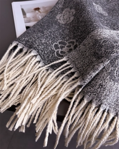 Close-up of camellia jacquard knit scarf with thick tassels and cashmere-like texture