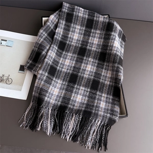 Close-up of classic British plaid scarf with soft tassels and orange line accents