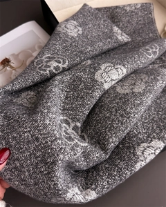 Detailed close-up of grey and white camellia flower jacquard cashmere scarf with tassels