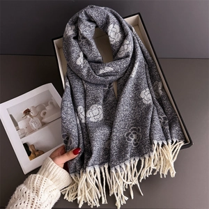 Detail of camellia floral knit scarf with delicate tassels and soft cashmere-like texture