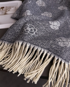 Detail of dark grey camellia pattern jacquard shawl with soft white fringe tassels