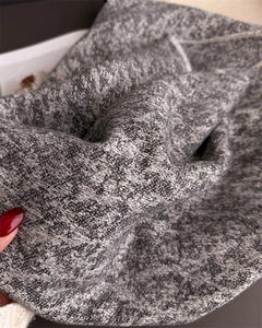 Macro view of high-quality grey knitted fabric showing soft cashmere-like texture and weave