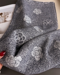 Detail of grey cashmere-like scarf showing luxury camellia patterns and woven texture