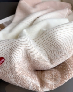 Detailed texture of a soft cashmere-blend scarf featuring pink beige color-block and patterns