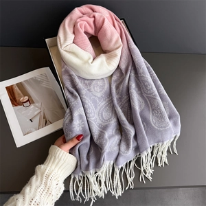 Detail of soft paisley knit scarf featuring pink and purple gradient with white fringes