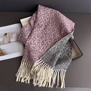 Close-up of winter thick knit scarf with burgundy and grey textures and cream tassels