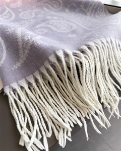 Detail of light purple paisley shawl with fine knit texture and soft white fringe tassels