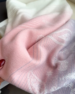 Detailed close-up of soft gradient cashmere scarf with white, pink, and purple twill texture