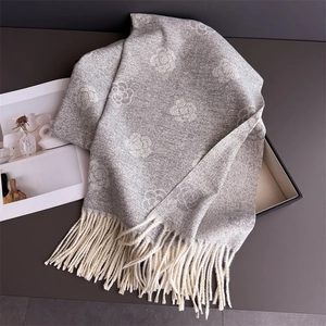 Detail of grey camellia pattern cashmere scarf featuring delicate ivory tassel fringe