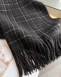 Close-up of thick plaid cashmere scarf with tassel fringe details and check pattern