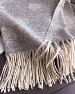 Macro detail of camellia jacquard texture and elegant tassels on gray cashmere scarf