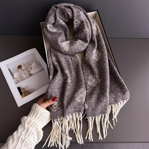 Detailed view of luxury dark grey scarf with camellia floral patterns and white tassels