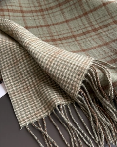 Close-up of soft green plaid scarf showing fine fringe detail and woven cashmere texture