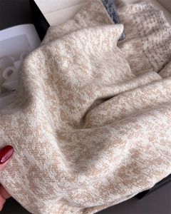 Macro detail of beige jacquard knit scarf with elegant oblique pattern and soft texture