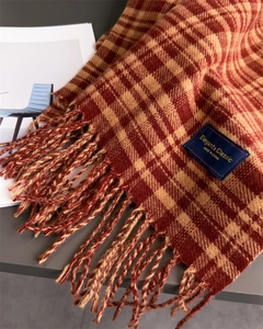 Detailed close-up of checkered scarf with soft tassels and elegant brand label