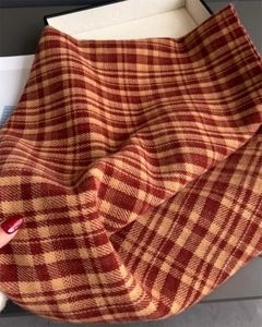 Detailed view of the thick brushed plaid texture on a warm cashmere-feel fringed scarf