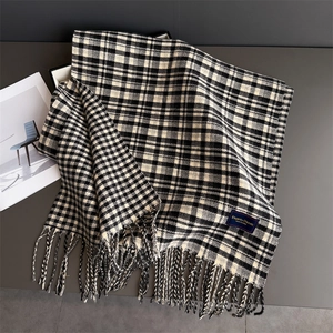 Detail shot of the soft plaid scarf fringe and the elegant classic woven brand label