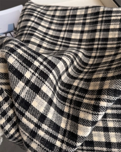 Detailed close-up of thick black and white plaid wool blend fabric with soft texture