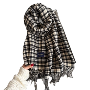 Classic black and white checkered scarf with fringe trim and elegant woven label detail
