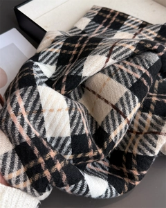 Close-up of thick plaid scarf featuring soft cashmere texture and woven twill pattern