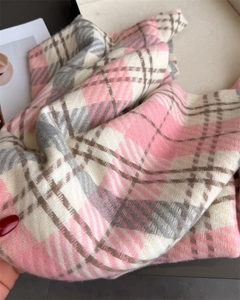 Detail view of the soft plaid scarf texture with pink and grey diagonal weave patterns