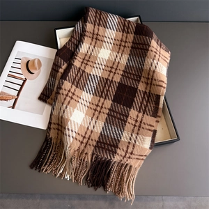 Detailed view of British plaid scarf texture with elegant tassels in brown and beige colors