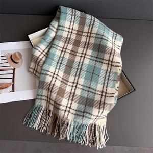 Close-up of blue and brown plaid cashmere scarf with long tassels in a gift box