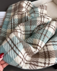 Close-up of soft blue and brown plaid scarf showing thick cashmere-like texture and fringe