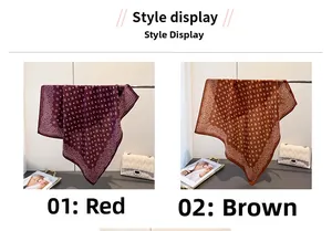 Detail view of red and brown paisley print silk scarves hanging on a metal rod
