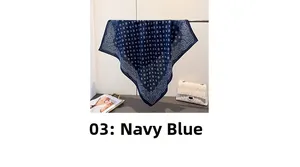Detail of navy blue paisley cotton linen scarf with elegant geometric patterns on a hanger