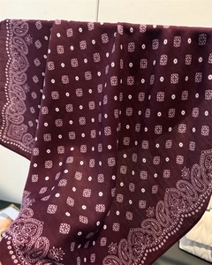 Macro detail of wine red paisley pattern cotton linen scarf with geometric dots