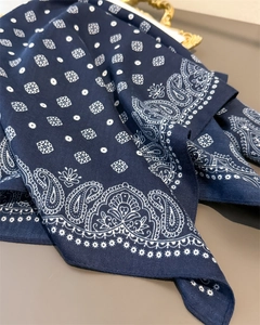 Detailed view of navy blue paisley pattern and texture on a cotton-linen feel square scarf