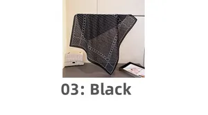 Detail of black silk-like scarf with white polka dot pattern and fine stitched edges