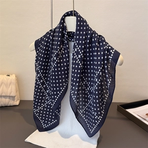Navy blue silk-like square scarf with white polka dot pattern on a mannequin