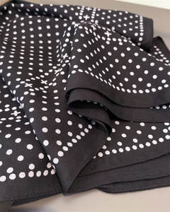 Detailed macro view of black and white polka dot scarf with premium twill weaving texture