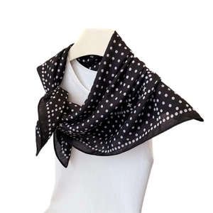 Minimalist black silk scarf with white polka dots and star pattern on mannequin display
