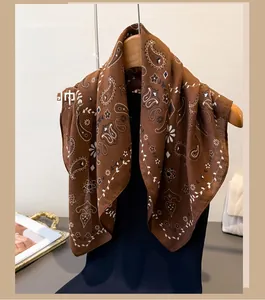 Detail of brown paisley pattern cotton linen scarf hanging on a wooden hanger