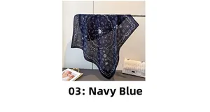 Navy blue paisley pattern square scarf draped with a stylish white quilted handbag