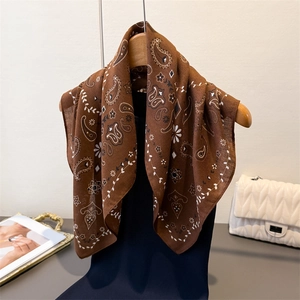 Brown paisley floral cotton-linen square scarf hanging on a wooden hanger gracefully