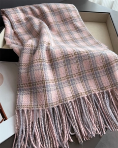 Détail d'une écharpe à carreaux rose et gris avec texture douce et fines franges