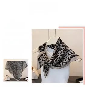 Close-up of elegant leopard print silk scarf with classic black and grey pattern detail