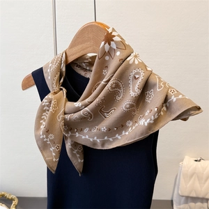 Close-up of a khaki paisley silk-like square scarf with elegant floral patterns