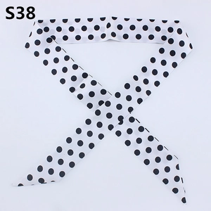 Close-up of slender white silk scarf with black polka dots and slanted ends detail