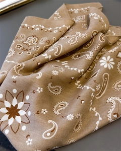 Detailed macro shot of herringbone texture and paisley pattern on the brown cotton scarf