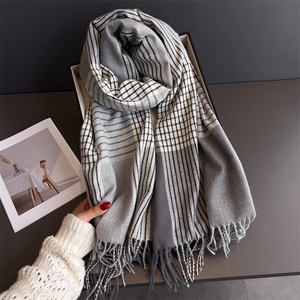 Detail of gray plaid scarf with long fringes in a white gift box for winter fashion