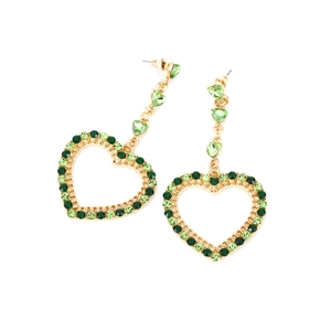 Dettaglio di lunghi orecchini dorati con pendenti a forma di cuore in cristallo verde